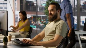 Meticulous staff member imputing data on computer in office. Adept worker at desk focused on typing company statistical numbers, working hard to finish job before deadline, camera A photo