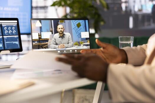 Staff member in modern startup office showing manager progress on customer commissioned project during videocall. Accountant presenting team leader key data statistics after business audit photo