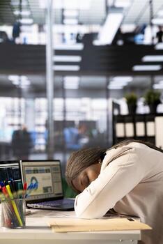 Exhausted worker falling asleep while doing tedious data entry job, inputting data on laptop. Fatigued african american woman suffering burnout, crashing down, lacking sleep while in office photo