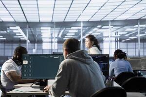 Admin in data center coding AI LLM chatbot software of virtual assistant answering user prompts using predictive technology. Worker building large language model program using artificial intelligence photo