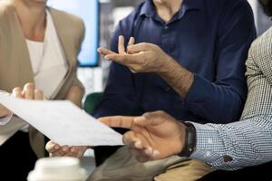Colleague doing briefing meeting to share new ideas for profit growth, presenting paperwork. Close up of employee in office talking with director, showing progress done on project photo