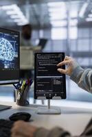 Admin uses machine learning applications on tablet to optimize data center operations, improving efficiency, ensuring longevity of infrastructure. Worker implementing server virtualization with device photo