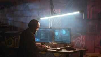 Hacker in foggy neon illuminated basement with graffiti drawings on walls using advanced technology computer, running code. Cybercriminal using dark underground warehouse as crime haven, camera B photo
