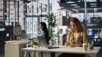 Female CEO engaging in project management using tech tools to set goals and objectives, solve problems and track the performance metrics of the company. Administrative tasks and decisions. Camera B. photo