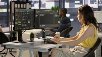 Manager in wheelchair passing by desk of employee testing machine learning company software to minimize occurrence of bugs. Woman works in inclusive workspace with workers with disabilities, camera A photo