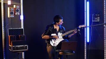 Rock artist doing a performance prep during rehearsal session, practicing her vocals for a live show. Musician singing during warm up session, focusing on vocal improvement. Camera B. photo