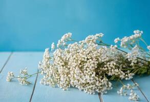 Bouquet of baby's breath on blue wooden table photo
