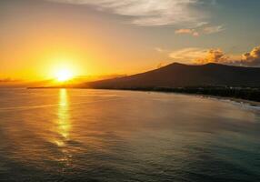 Sunset over the ocean and mountains in the background photo