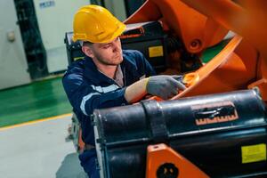 Worker performs maintenance on machinery in a factory, ensuring equipment operates efficiently and safely in an industrial setting photo