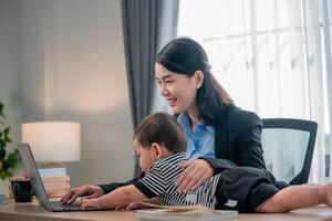 Mother working from home with child playing on her lap in a cozy office setting photo