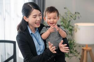 Mother joyfully interacts with her young child in a bright, modern home office setting photo