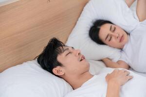 Couple peacefully sleeping in a cozy bedroom with soft pillows and warm lighting at night photo