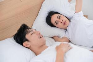 Couple in bed experiencing discomfort during sleep in a bright room photo