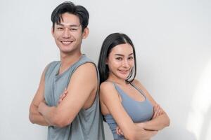 Young adults pose confidently back to back in a casual studio setting, showcasing their fitness journey photo