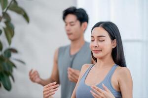 Couple practicing mindfulness meditation in a serene indoor setting with natural light photo