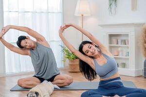 Couple practicing yoga together at home with a playful dog in a cozy living room setting photo