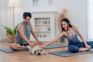 Couple enjoys a relaxing yoga session with their pet dog in a serene indoor space during a sunny morning photo