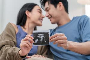Expecting joy as couple shares ultrasound image in cozy living room setting photo