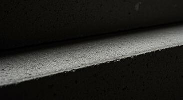 Abstract Closeup of Dark Grey Textured Blocks Stacked Horizontally Showing Subtle Light and Shadow Play photo