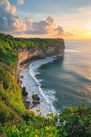 vertical image serene coastal cliffs with soft waves crashing on the shore surrounded by vibrant greenery in warm afternoon sunlight photo