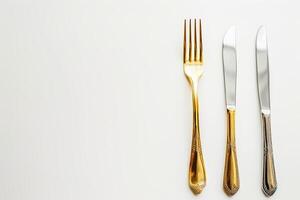 Gold flatware set includes a fork and knife displayed against a crisp white background photo