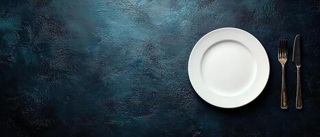 Minimalist Dining Concept with an Empty White Plate and Vintage Cutlery on Dark Textured Background photo