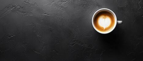 Latte with Heart Foam on a Dark Textured Surface with Copy Space photo
