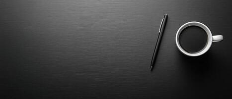 Top-Down View of a Coffee Cup and Pen on a Dark Wooden Desk with Copy Space photo