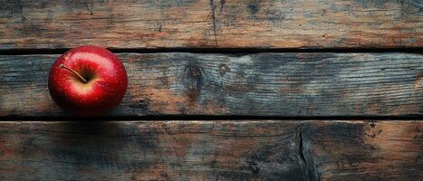 Fresh Red Apple on Rustic Wooden Table with Weathered Texture and Natural Light photo