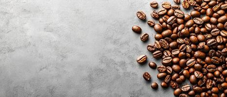 Scattered Roasted Coffee Beans on a Smooth Grey Textured Background with Copy Space photo