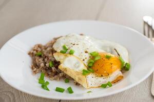 Warm serving of breakfast with scrambled eggs and boiled buckwheat photo