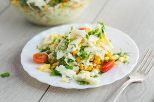Diet salad with cabbage.Chinese cabbage salad with squid, eggs, tomatoes and other vegetables photo