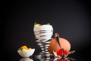 Simple diet breakfast.delicacy with red caviar and boiled egg for breakfast, isolated on black background photo