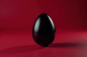 Reflective black egg on a deep red background, modern and artistic Easter look photo