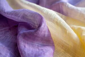 A close view reveals the gentle undulations of fabric that transition from vibrant purple to soft yellow, emphasizing texture and color variety photo