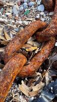 Close-up of a large rusty chain on a pebble beach. High quality photos