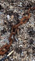 Close-up of large links of rusty chain on pebble beach after storm. High quality photos. photo