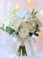 A beautifully arranged bouquet features white roses and lilies, elegantly tied with a silk ribbon, creating a soft romantic atmosphere. photo