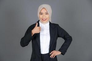 Portrait of Young Confident Woman in a Hijab Thumbs Up in Approval or Recommendation And Smiling photo