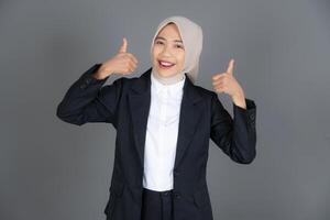Portrait of Young Confident Female in a Hijab Thumbs Up in Approval or Recommendation Background photo