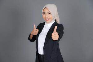 Portrait of Young Confident Woman in a Hijab Thumbs Up in Approval or Recommendation Isolated Background photo