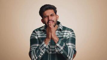 Indian man showing a little bit gesture with sceptic smile showing minimum sign measuring small size video