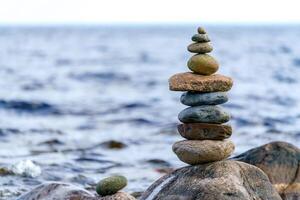 Pyramid of flat stones. Unstable balance of stone objects. Idyllic state of nature. photo