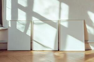 Three blank frames sit on a wooden floor photo
