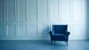 A blue chair in front of a white wall photo