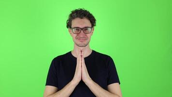 man calm, happy expression greets with hands clasped in front. sign namaste symbol, Indian greeting. isolated on green studio background, chromakey. Concept - mental health, meditation, yoga, calmness video