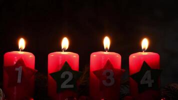 New year and Christmas preparation. Four red advent candles with numbers burning in dark background. Handmade eco-friendly decor. Sustainable Christmas decoration at night video