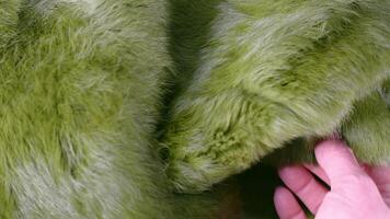 Soft green plush fabric revealing luxurious texture through gentle hand stroking, exploring delicate surface and fabric quality with tactile, close-up sensation video