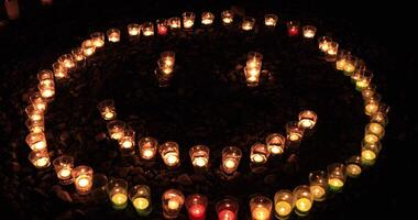 Burning romantic candles by laying out like smile mark at night video