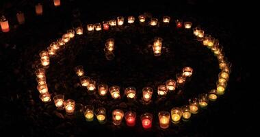 Burning romantic candles by laying out like smile mark at night video
